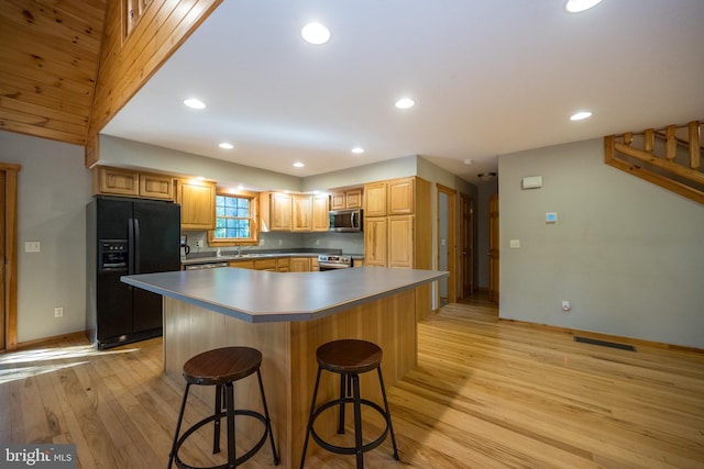 129 Bucks Crossing Ln, Accident, MD 21520 - kitchen with appliances with stainless steel finishes, light wood-type flooring, a breakfast bar, recessed lighting, and a kitchen island