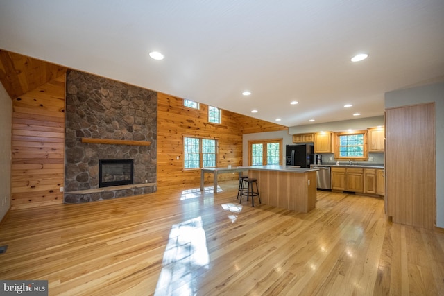 129 Bucks Crossing Ln, Accident, MD 21520 - kitchen featuring stainless steel dishwasher, black fridge with ice dispenser, a center island, light wood-type flooring, and wooden walls