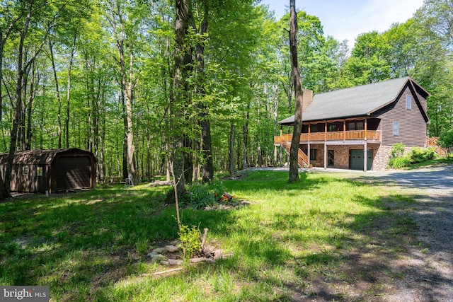 129 Bucks Crossing Ln, Accident, MD 21520 - view of grassy yard featuring a shed, dirt driveway, an attached garage, and a wooden deck