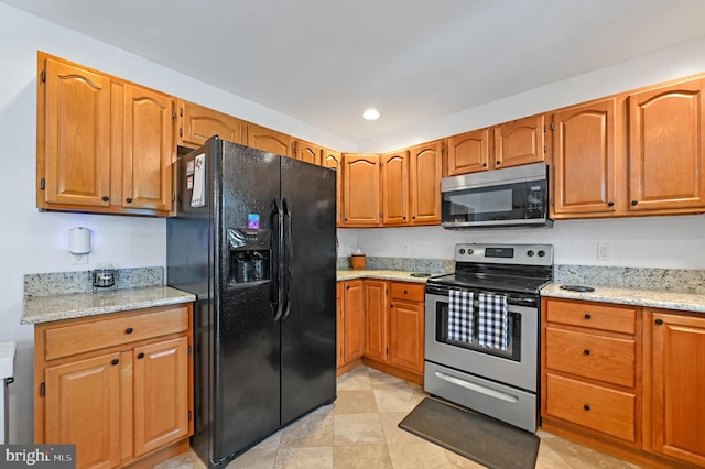 11684 Kensington Way, Laurel, DE 19956 - kitchen with stainless steel appliances, light stone countertops, brown cabinets, recessed lighting, and light tile patterned flooring