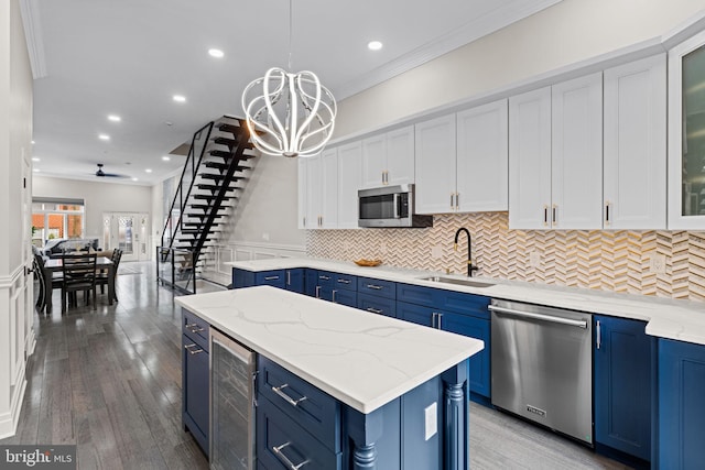 933 S 3rd St, Philadelphia, PA 19147 - kitchen featuring blue cabinetry, appliances with stainless steel finishes, beverage cooler, ornamental molding, and recessed lighting