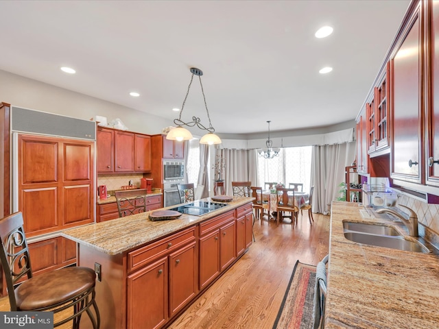 3002 Ridgeview Dr, Orwigsburg, PA 17961 - kitchen with a sink, a kitchen island, light wood-style floors, backsplash, and appliances with stainless steel finishes