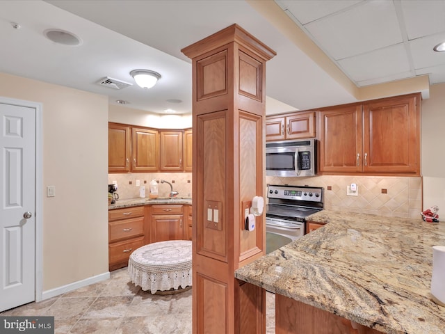 3002 Ridgeview Dr, Orwigsburg, PA 17961 - kitchen featuring appliances with stainless steel finishes, a sink, light stone counters, decorative backsplash, and baseboards