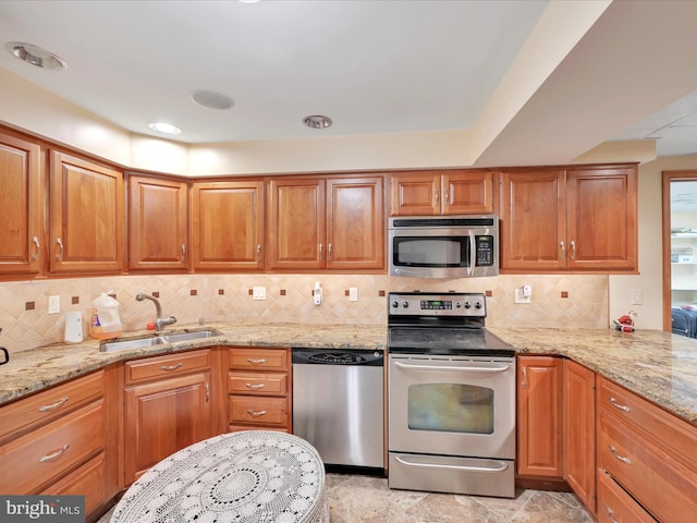 3002 Ridgeview Dr, Orwigsburg, PA 17961 - kitchen featuring appliances with stainless steel finishes, a sink, light stone countertops, tasteful backsplash, and brown cabinets