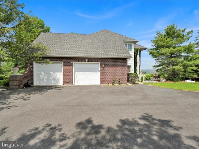 3002 Ridgeview Dr, Orwigsburg, PA 17961 - view of property exterior featuring brick siding, roof with shingles, a garage, and driveway