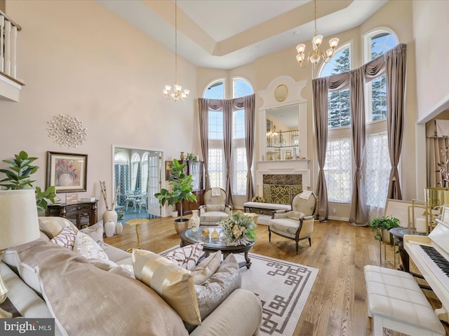 3002 Ridgeview Dr, Orwigsburg, PA 17961 - living room with a chandelier, a high ceiling, wood finished floors, and a fireplace with raised hearth