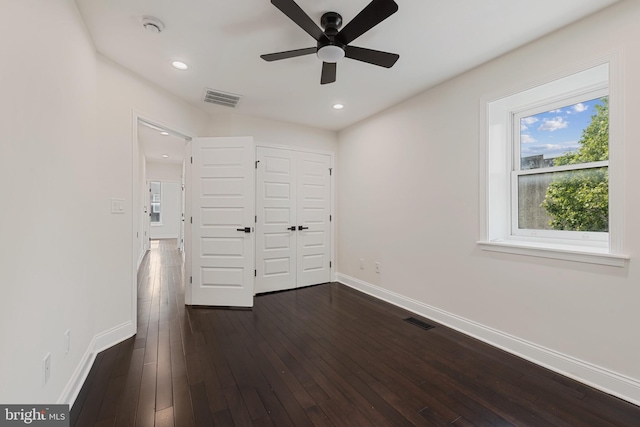 148 S E Ave, Baltimore, MD 21224 - unfurnished bedroom featuring baseboards, multiple windows, dark wood-style floors, recessed lighting, and a closet