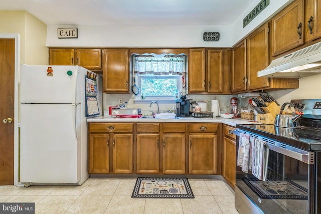 148 Belmont Dr, Upper Chichester, PA 19061 - kitchen featuring stainless steel electric stove, freestanding refrigerator, under cabinet range hood, and brown cabinets