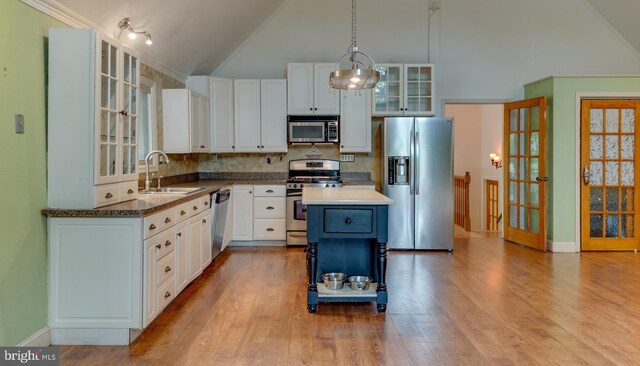 26747 Cat Creek Rd, Mechanicsville, MD 20659 - kitchen with stainless steel appliances, a sink, light wood-style floors, white cabinets, and decorative backsplash