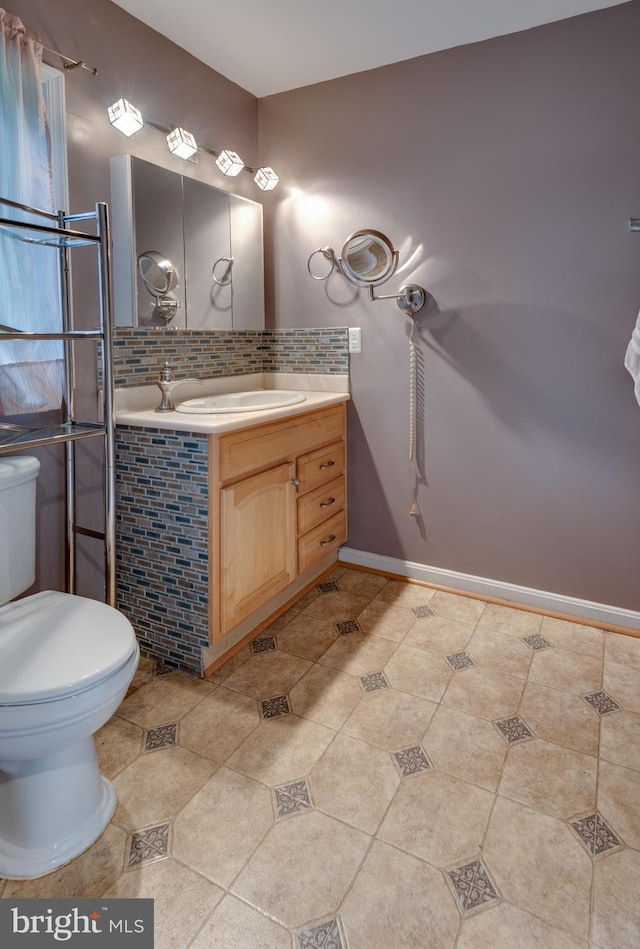 26747 Cat Creek Rd, Mechanicsville, MD 20659 - bathroom featuring vanity, toilet, decorative backsplash, baseboards, and tile patterned flooring