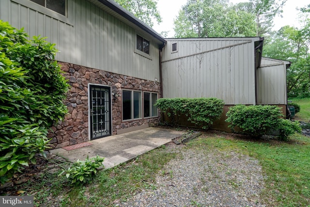 26747 Cat Creek Rd, Mechanicsville, MD 20659 - back of property with stone siding, a patio, and board and batten siding