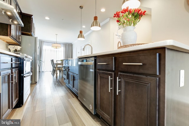 3409 Stone Barn Dr, Frederick, MD 21704 - kitchen with exhaust hood, stainless steel appliances, dark brown cabinetry, light wood finished floors, and pendant lighting