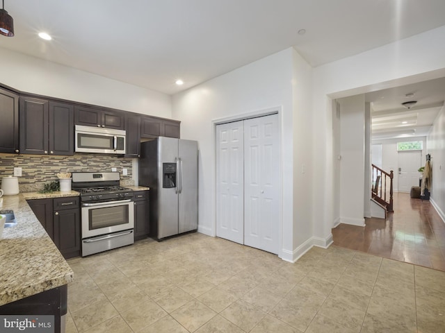 1705 E Chase St, Baltimore, MD 21213 - kitchen with stainless steel appliances, backsplash, light tile patterned floors, and dark brown cabinetry