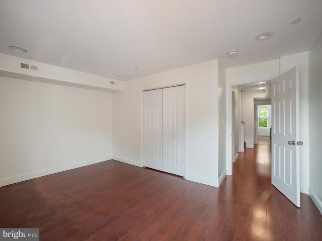 1705 E Chase St, Baltimore, MD 21213 - unfurnished bedroom featuring dark wood-type flooring, baseboards, and a closet