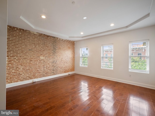 1705 E Chase St, Baltimore, MD 21213 - unfurnished room with brick wall, a raised ceiling, baseboards, hardwood / wood-style flooring, and plenty of natural light