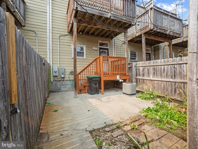 1705 E Chase St, Baltimore, MD 21213 - rear view of house featuring a fenced backyard, a wooden deck, central AC unit, and a patio area