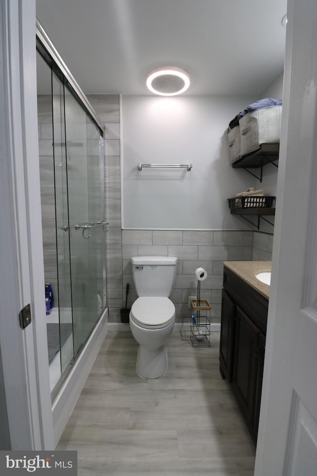 14 Riverside Rd, Dover, DE 19904 - full bath with wood finished floors, tile walls, a shower stall, vanity, and wainscoting