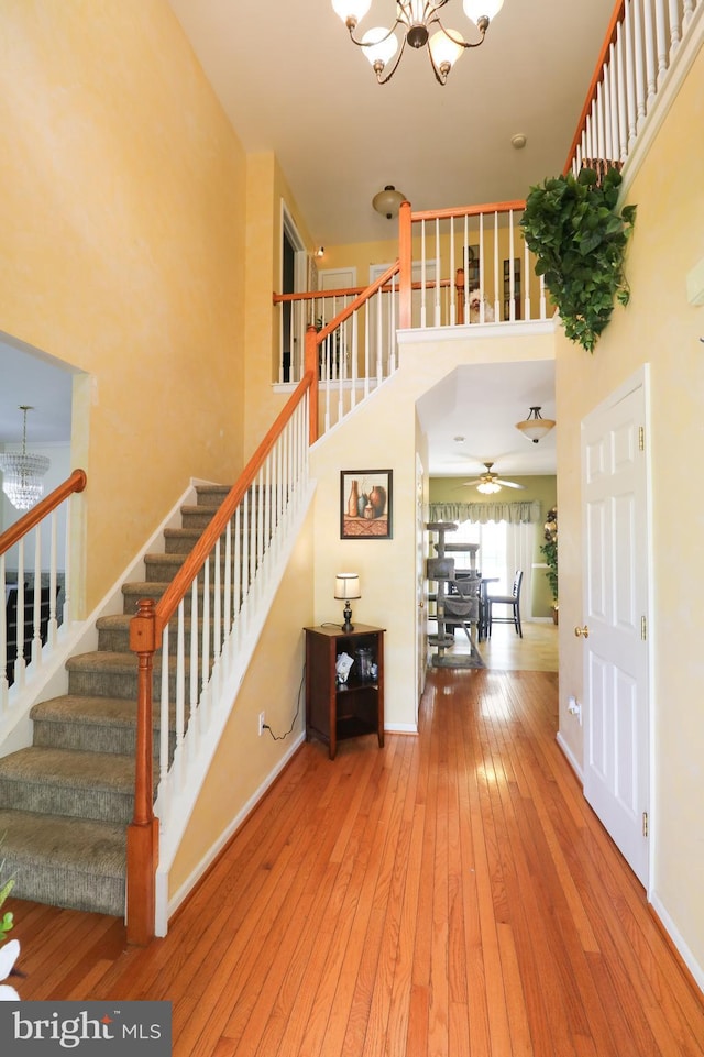 14 Riverside Rd, Dover, DE 19904 - stairway featuring a chandelier, hardwood / wood-style floors, a high ceiling, and ceiling fan
