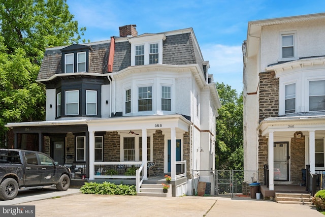 358 W Duval St, Philadelphia, PA 19144 - view of front facade featuring covered porch, stone siding, and a chimney