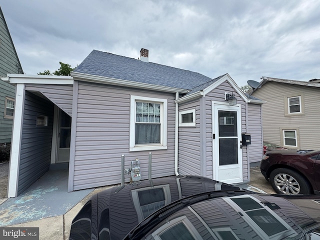 1213 W College Ave, York, PA 17404 - back of property with a chimney, outdoor dining space, roof with shingles, and a patio area