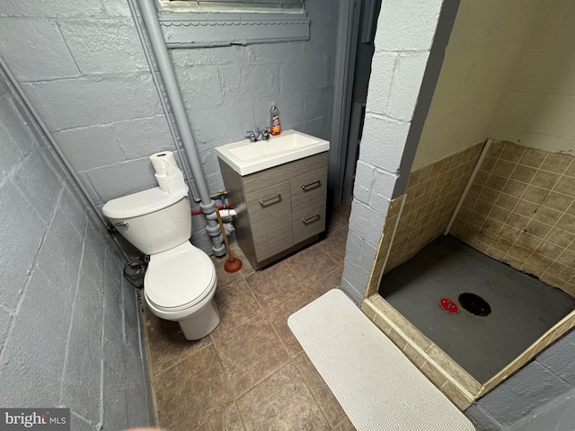 1213 W College Ave, York, PA 17404 - bathroom with toilet, vanity, a shower stall, and concrete block wall