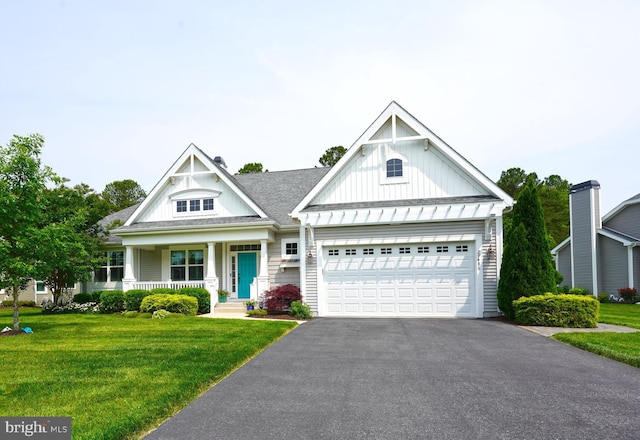 29486 Andrew Jackson Dr, Millsboro, DE 19966 - view of front of home featuring board and batten siding, asphalt driveway, a front lawn, an attached garage, and a porch