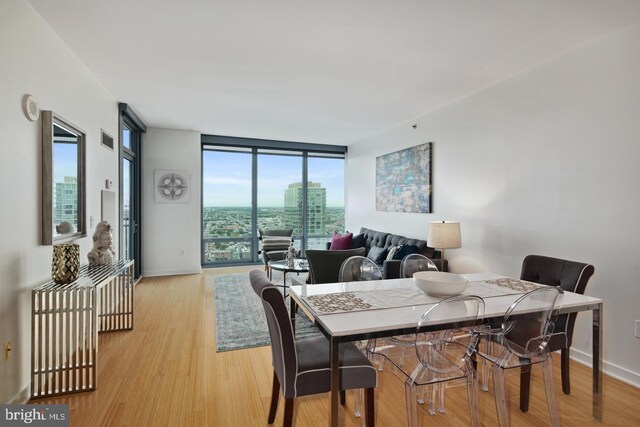 2101 Market St Unit 3605, Philadelphia, PA 19103 - dining space featuring expansive windows, light wood-style flooring, and baseboards