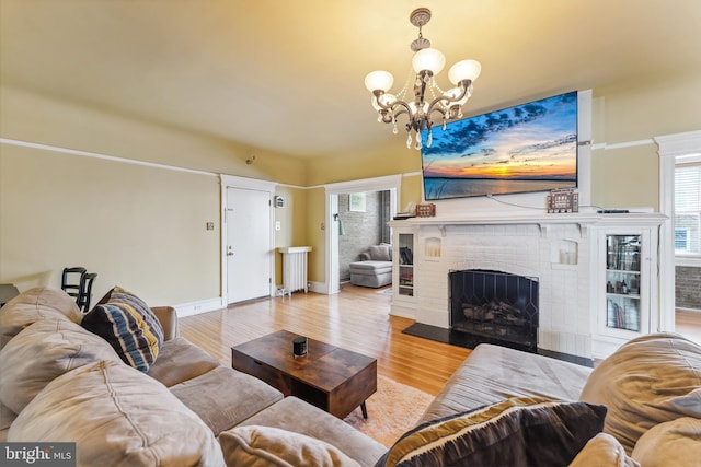 1 S Bartram Ave Unit 3, Atlantic City, NJ 08401 - living room featuring wood finished floors, a chandelier, a brick fireplace, and baseboards