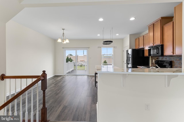 326 Iannelli Rd, Clarksboro, NJ 08020 - kitchen with black appliances, dark wood finished floors, brown cabinetry, a breakfast bar, and light countertops