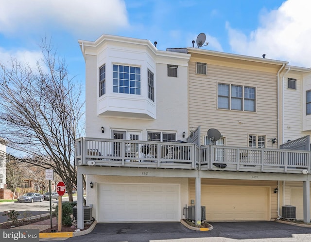 8861 Ashgrove House Ln, Vienna, VA 22182 - back of house with cooling unit, driveway, and an attached garage