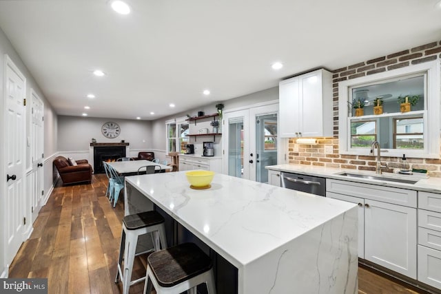 11636 Doxdam Ter, Germantown, MD 20876 - kitchen featuring a sink, a lit fireplace, stainless steel dishwasher, dark wood finished floors, and a center island