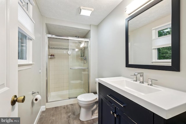 11636 Doxdam Ter, Germantown, MD 20876 - bathroom with wood finished floors, toilet, vanity, a stall shower, and a textured ceiling