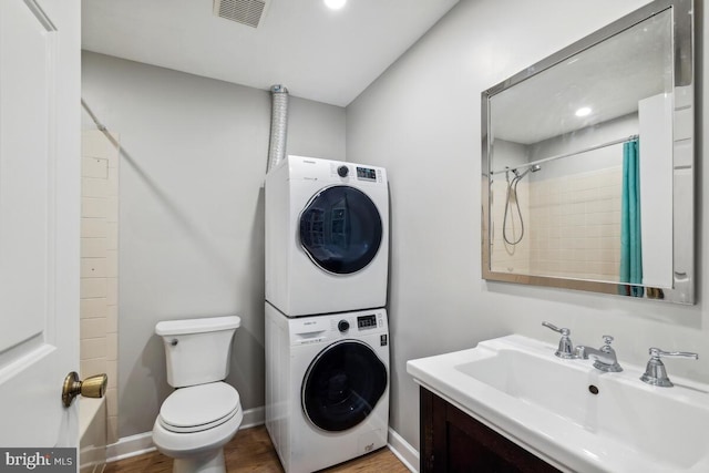 11636 Doxdam Ter, Germantown, MD 20876 - full bath with stacked washer / drying machine, toilet, wood finished floors, a shower with shower curtain, and vanity