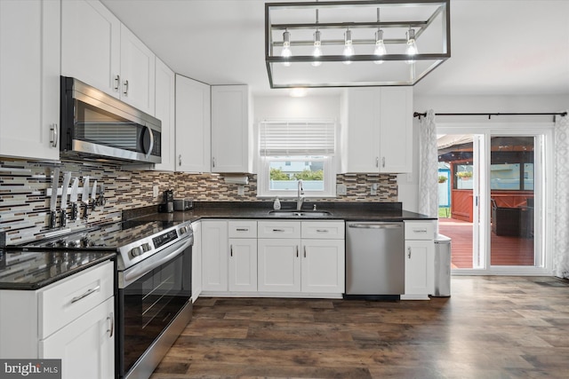 123 E Violette Dr, New Castle, DE 19720 - kitchen with appliances with stainless steel finishes, a sink, dark countertops, and decorative backsplash