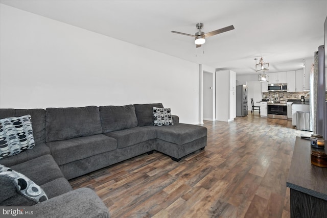 123 E Violette Dr, New Castle, DE 19720 - living area with dark wood-style flooring, ceiling fan, and baseboards