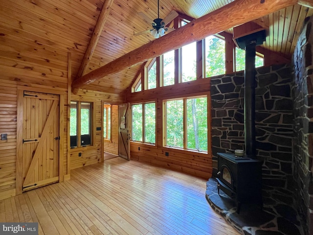 11882 Bumbarger Cir, Petersburg, PA 16669 - unfurnished living room featuring a wood stove, light wood-style flooring, wooden walls, wooden ceiling, and a ceiling fan