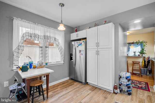 5409 20th Ave, Hyattsville, MD 20782 - kitchen with stainless steel refrigerator with ice dispenser, white cabinets, light wood-style floors, and baseboards