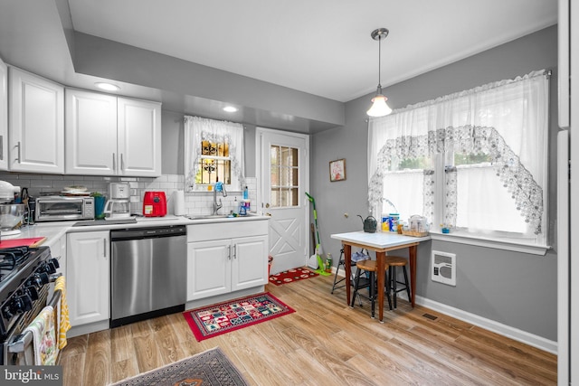 5409 20th Ave, Hyattsville, MD 20782 - kitchen featuring stainless steel dishwasher, a sink, gas range, light countertops, and white cabinetry