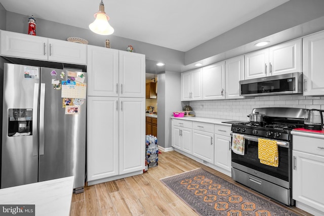 5409 20th Ave, Hyattsville, MD 20782 - kitchen featuring stainless steel appliances, light countertops, white cabinets, light wood-type flooring, and backsplash