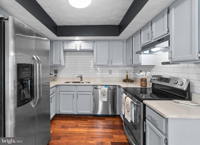 7967 Brightmeadow Ct, Ellicott City, MD 21043 - kitchen featuring stainless steel appliances, under cabinet range hood, dark wood-style flooring, a textured ceiling, and light countertops