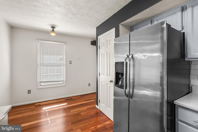 7967 Brightmeadow Ct, Ellicott City, MD 21043 - kitchen with stainless steel fridge with ice dispenser, dark wood finished floors, light countertops, gray cabinets, and a textured ceiling