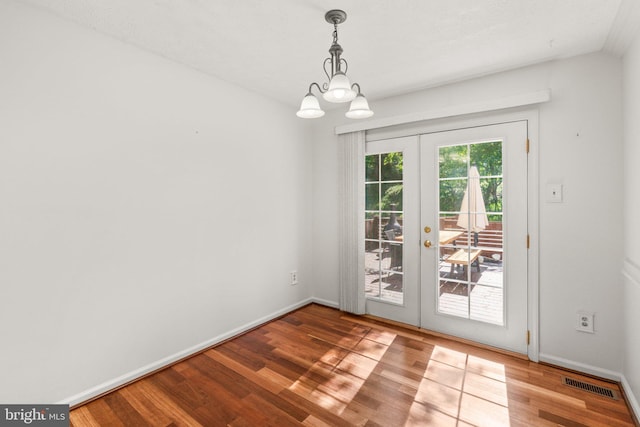 7967 Brightmeadow Ct, Ellicott City, MD 21043 - unfurnished dining area featuring french doors, wood finished floors, and a chandelier