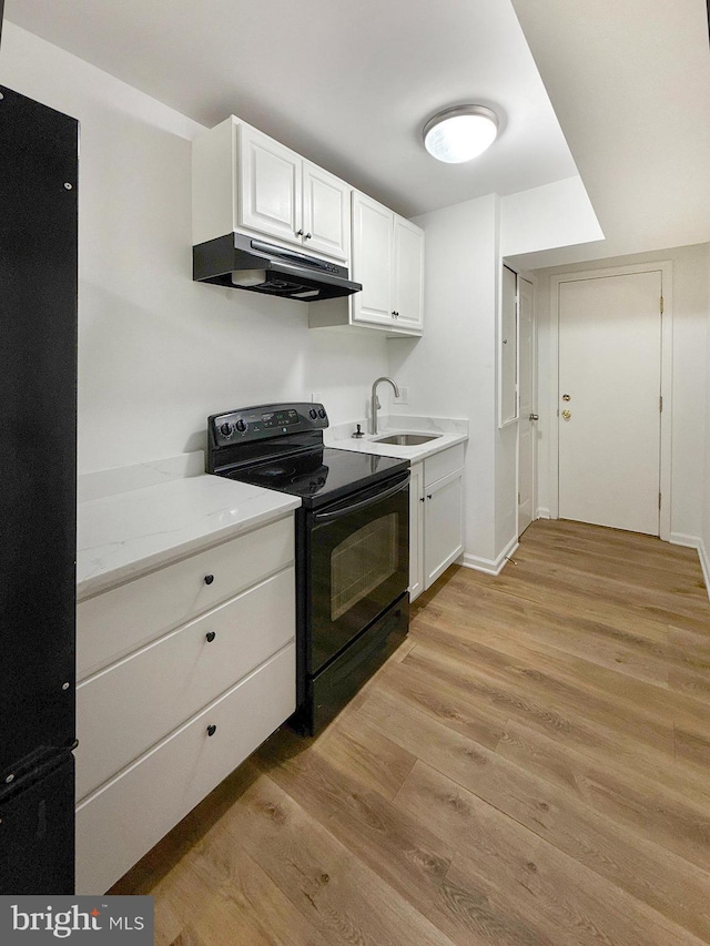 1308 Gallaudet St NE, Washington, DC 20002 - kitchen with black appliances, under cabinet range hood, light wood finished floors, white cabinetry, and light countertops