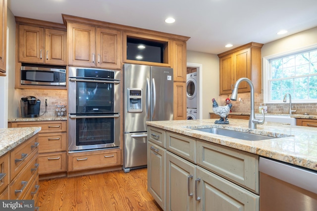 17 Bridleshire Rd, Newark, DE 19711 - kitchen with stainless steel appliances, stacked washing machine and dryer, a sink, recessed lighting, and light wood-style floors