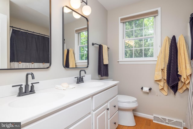 17 Bridleshire Rd, Newark, DE 19711 - bathroom with healthy amount of natural light, double vanity, toilet, and wood finished floors