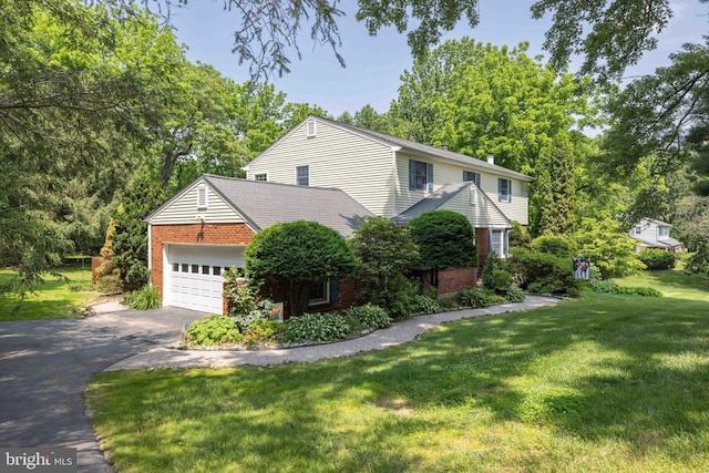 17 Bridleshire Rd, Newark, DE 19711 - view of side of home featuring brick siding, asphalt driveway, an attached garage, and a lawn