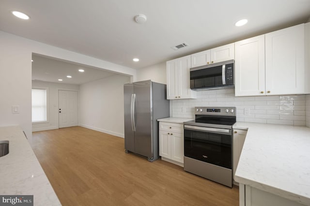 323 Sheridan Dr, New Castle, DE 19720 - kitchen with appliances with stainless steel finishes, light wood-style floors, white cabinets, backsplash, and recessed lighting
