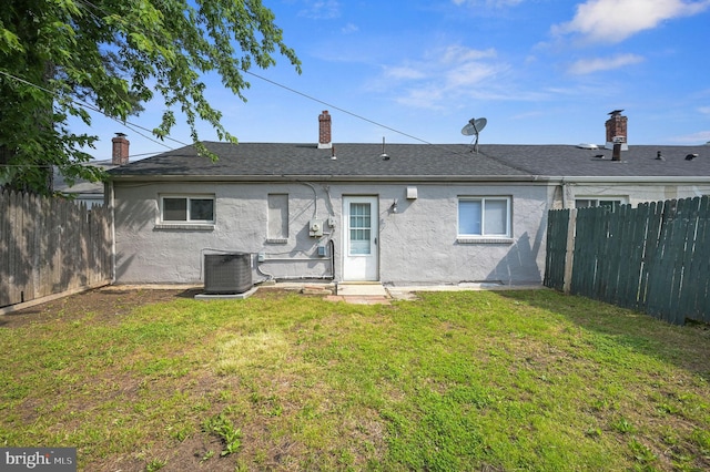 323 Sheridan Dr, New Castle, DE 19720 - back of property with stucco siding, central AC, and a chimney
