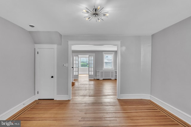 1004 N 67th St, Philadelphia, PA 19151 - unfurnished room featuring light wood-style floors, radiator, a chandelier, and baseboards