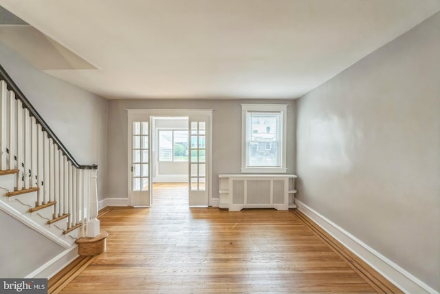 1004 N 67th St, Philadelphia, PA 19151 - foyer with radiator heating unit, light wood finished floors, baseboards, and stairs